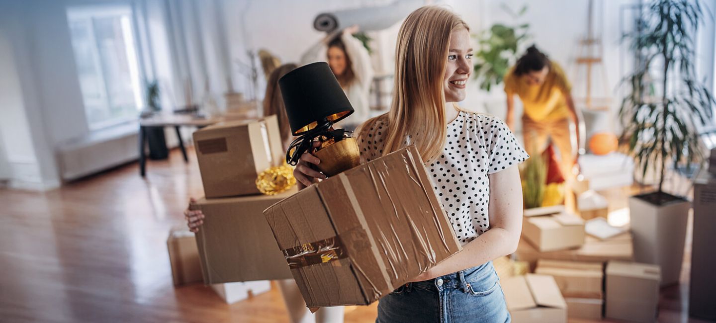 Junge Frau mit Paket in der Hand beim Umzug