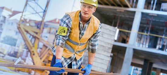 Bauarbeiter hält Rohre